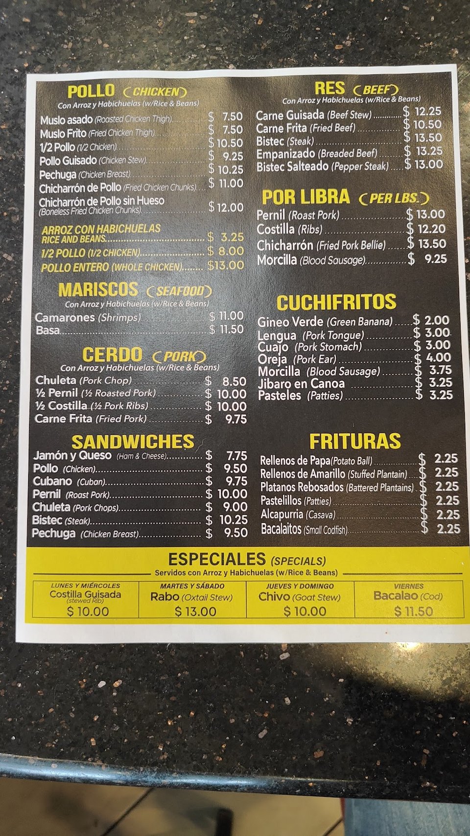 Spanish-language menu listing mofongo and fritters.